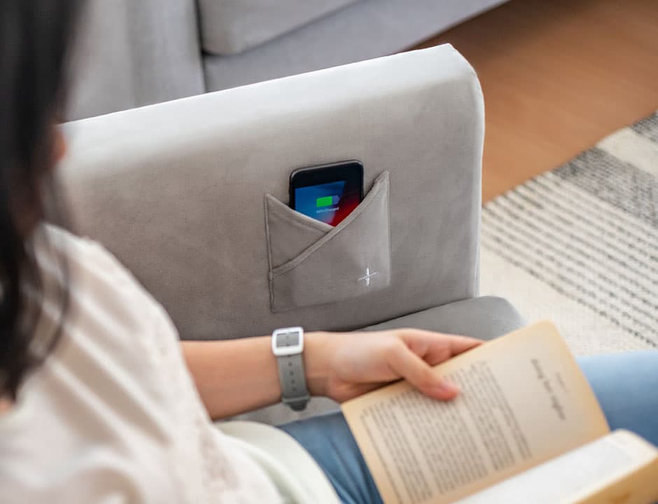 lady reading book on IKEA Koarp covered in velvet sofa cover slipcover with wireless charger pocket